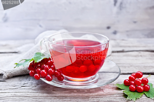 Image of Tea from viburnum in cup with berries on gray wooden board