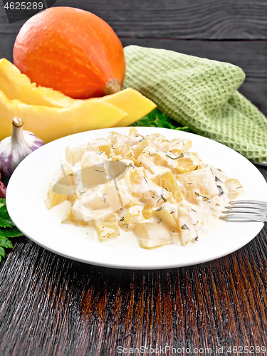 Image of Pumpkin with sour cream sauce in plate on wooden table