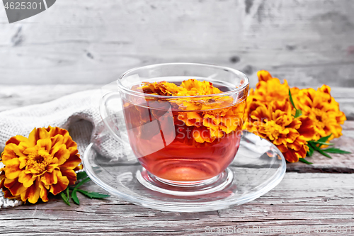 Image of Tea herbal of marigolds in glass cup on board