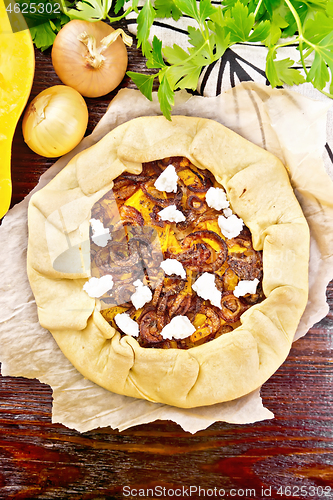 Image of Pie with pumpkin and onions on wooden board top