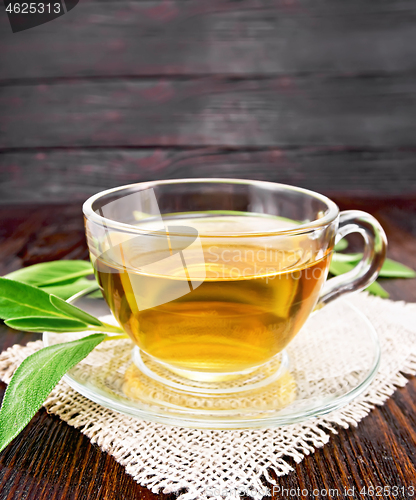 Image of Tea herbal with sage in glass cup on wooden board