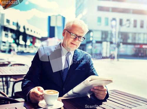 Image of senior businessman with newspaper drinking coffee