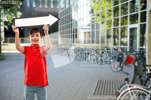 Image of boy holding big white rightwards thick arrow