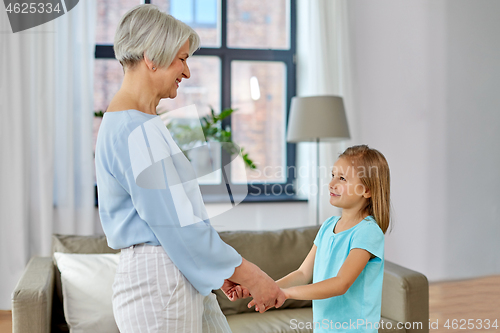 Image of grandmother and granddaughter holding hands