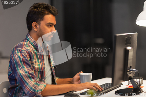 Image of creative man with computer working at night office