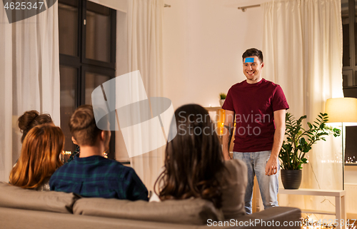 Image of friends playing guessing game at home in evening