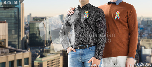 Image of close up of couple with gay pride rainbow ribbons