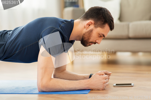 Image of man doing plank exercise at home