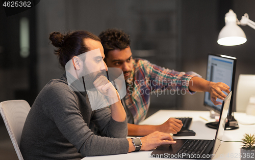 Image of creative team with computer working late at office