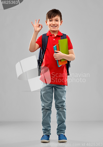 Image of student boy with books and school bag showing ok