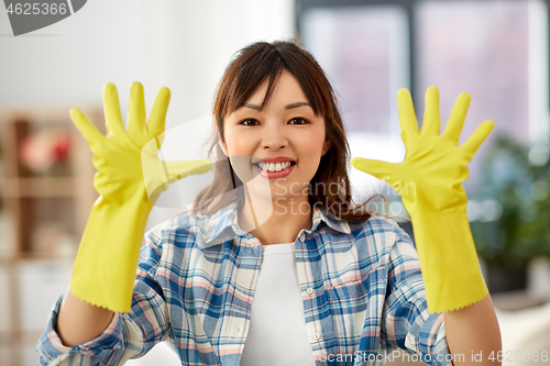 Image of asian woman in rubber gloves cleaning at home