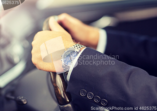 Image of senior businessman hands driving car