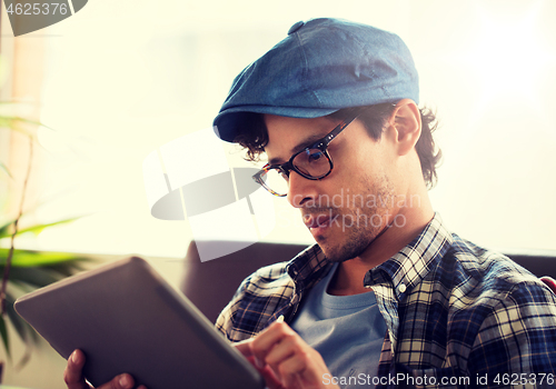 Image of close up of man with tablet pc sitting at cafe