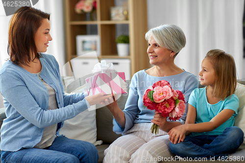 Image of female family giving present to grandmother