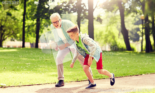 Image of grandfather and grandson racing at summer park