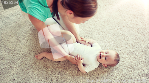 Image of happy mother playing with baby at home