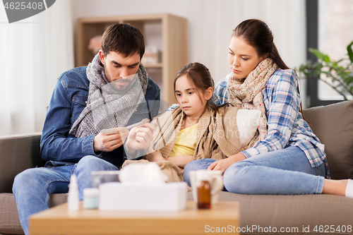 Image of family with ill daughter having fever at home