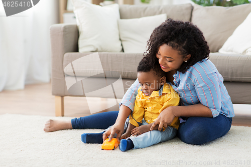 Image of mother and baby playing with toy car at home
