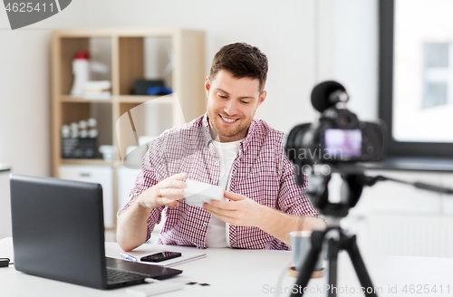 Image of male blogger with camera videoblogging at home