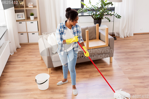 Image of african woman or housewife cleaning floor at home