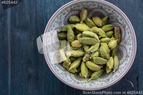 Image of Green cardamom whole seeds in vintage bowl