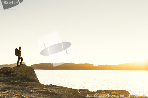 Image of Man exploring the coast line at sunset