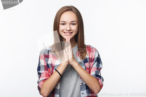 Image of Smiling girl greeting with a gesture with palms pressed together