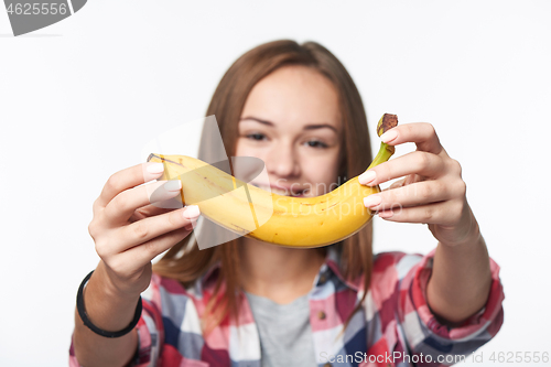 Image of Teen girl outstretching giving you a banana