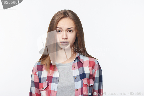 Image of Discontent confused teen girl looking at camera