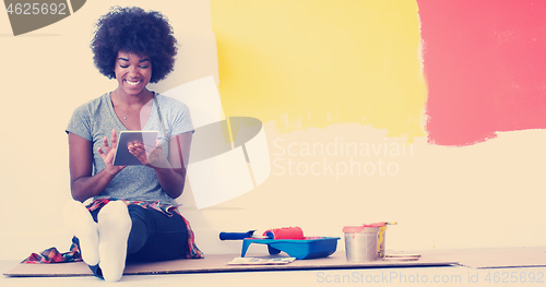 Image of black female painter sitting on floor