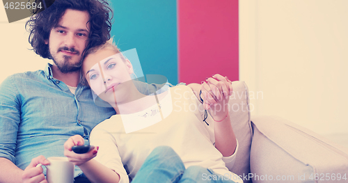 Image of Young couple on the sofa watching television