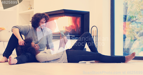 Image of multiethnic couple using tablet computer on the floor