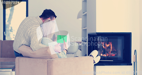 Image of couple relaxing at  home with tablet computers