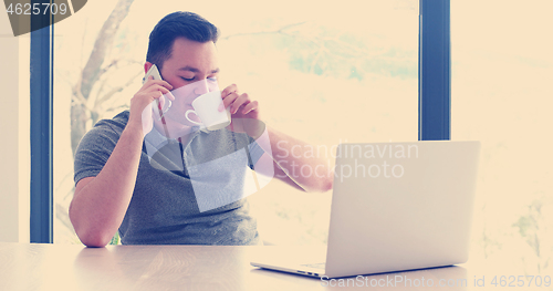 Image of businessman working using a laptop in startup office