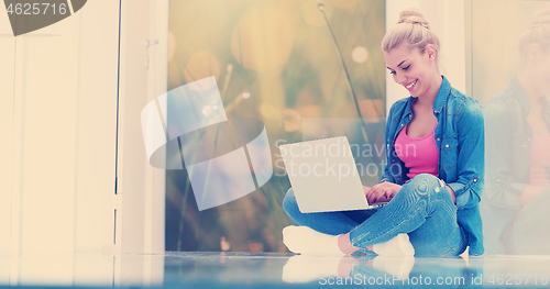 Image of young women using laptop computer on the floor