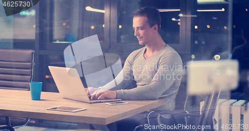 Image of man working on laptop in dark office