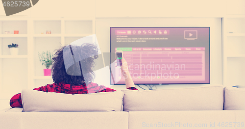 Image of Young couple on the sofa watching television