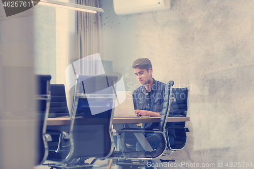 Image of businessman working using a laptop in startup office