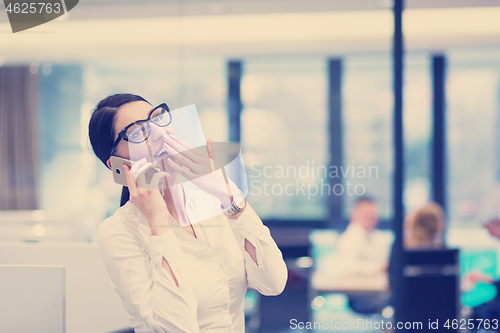 Image of Elegant Woman Using Mobile Phone in startup office building