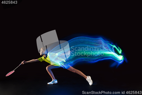 Image of one caucasian young teenager girl woman playing Badminton player on black background