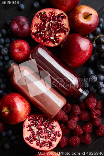 Image of Mix of fresh red and black fruits. With botteled fresh juices