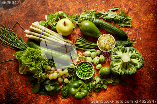 Image of Fresh green vegetables and fruits assortment placed on a rusty metal