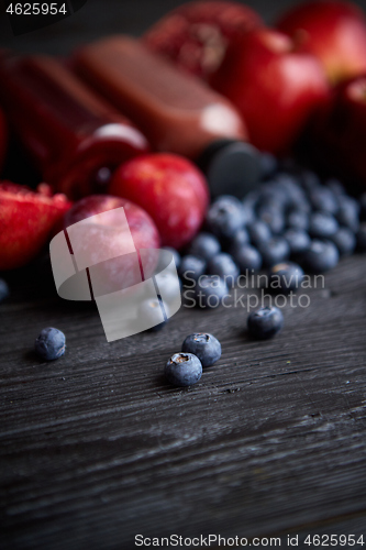 Image of Mix of fresh red and black fruits. With botteled fresh juices