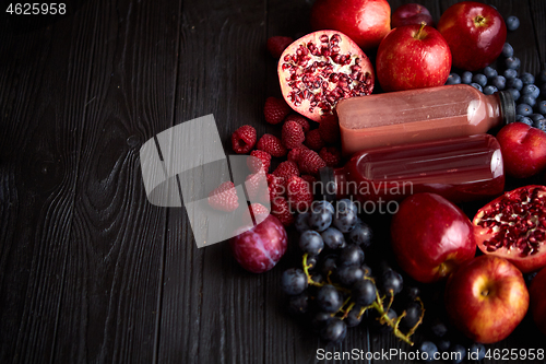 Image of Mix of fresh red and black fruits. With botteled fresh juices