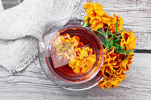 Image of Tea herbal of marigolds in glass cup on board top