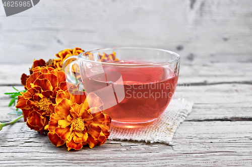 Image of Tea herbal of marigolds in cup on burlap