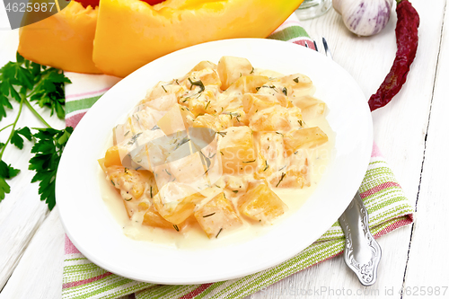 Image of Pumpkin with sour cream sauce in plate on light wooden board