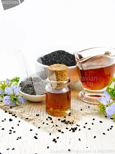 Image of Oil kalingi in bottle and gravy boat on light wooden board