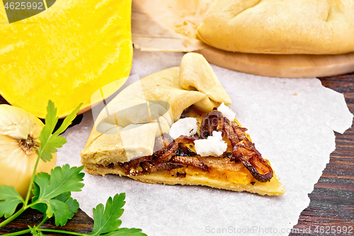 Image of Pie with pumpkin and fried onions on wooden board