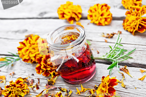 Image of Alcohol tincture of marigolds in jar on board